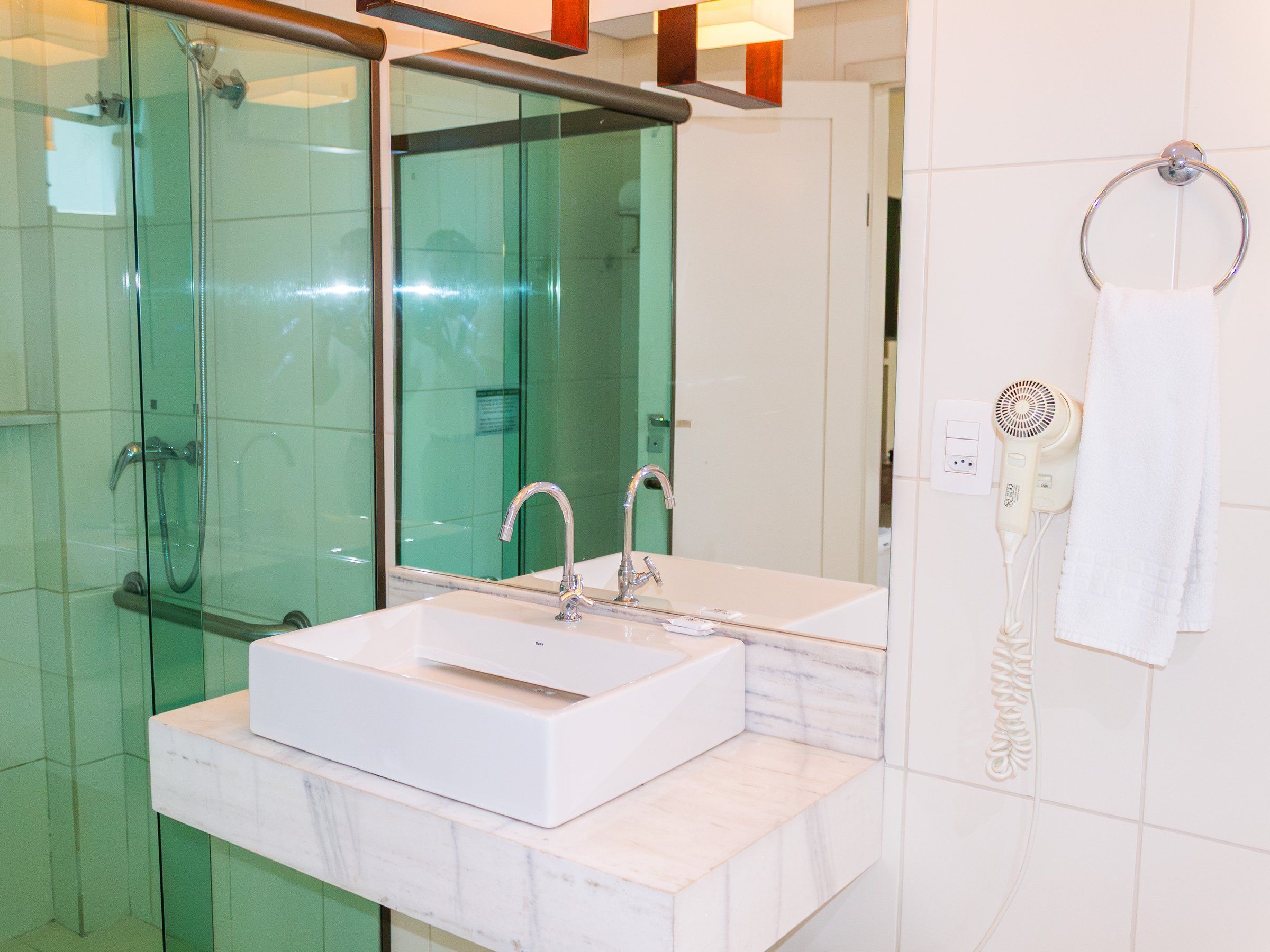 Bathroom with a glass shower, white sink and hair dryer