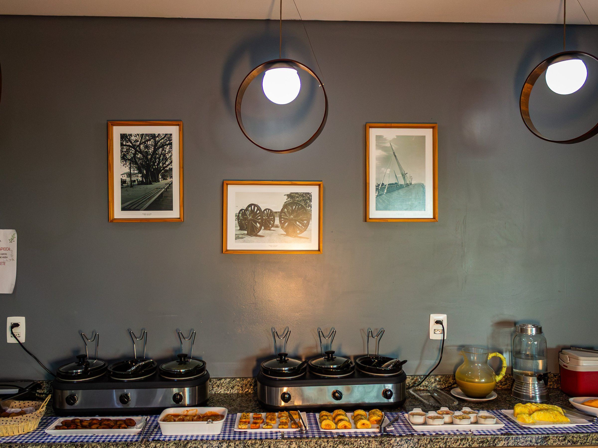 Breakfast buffet with hot dishes and framed pictures on the wall