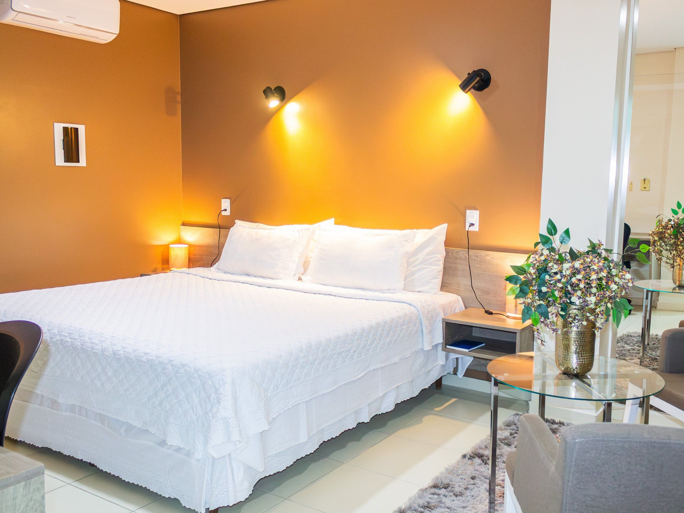 Master Suite at Amazônia Palace Hotel with a double bed, wall lamps and an orange wall
