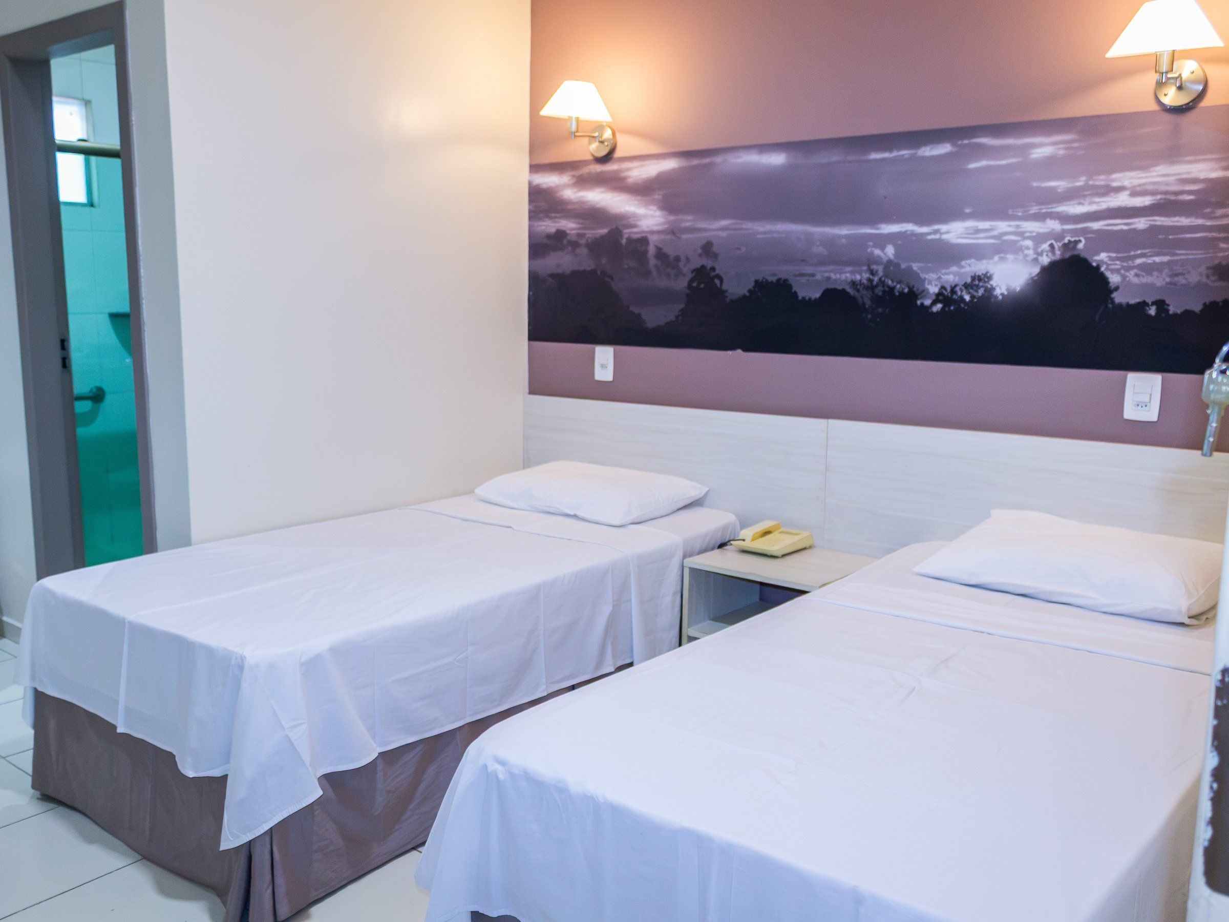 Deluxe Triple room, two single beds with a landscape panel above the headboards