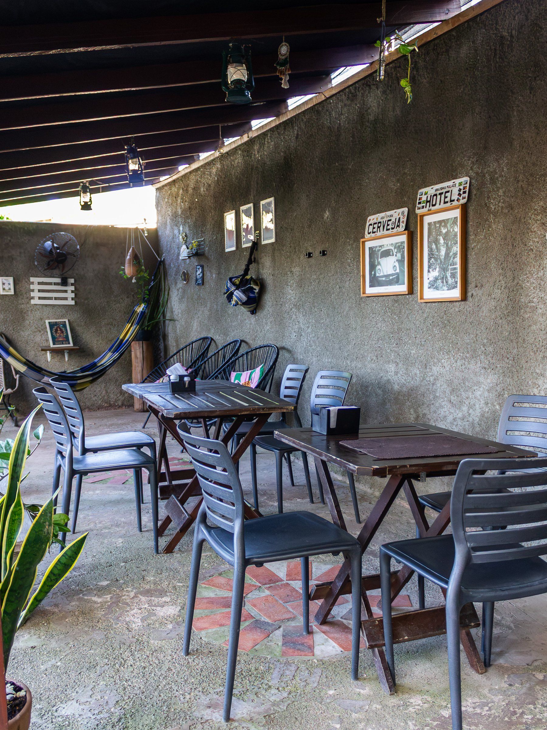 Hotel veranda with tables, chairs and a hammock